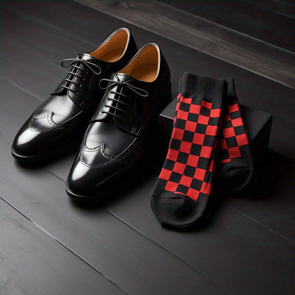 A pair of black leather wingtip dress shoes next to red and black checkered socks on a dark wooden surface, showcasing an elegant combination of footwear and accessory.